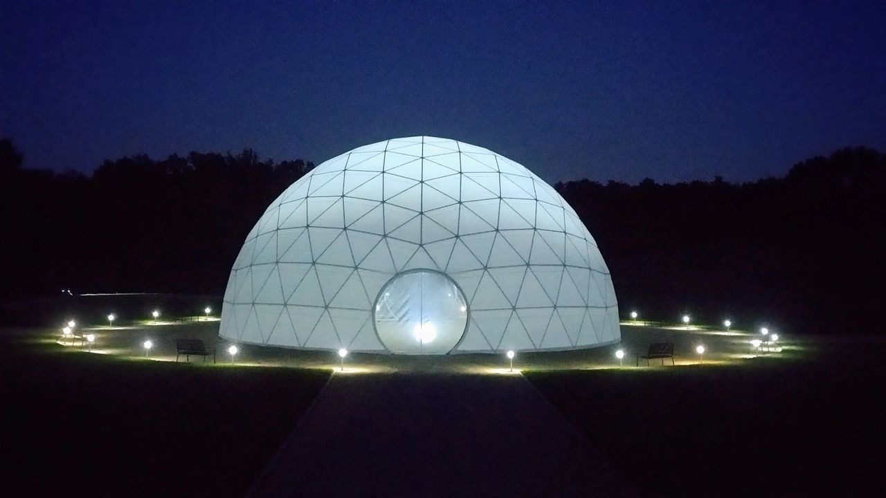 A large white dome with lights on top of it.