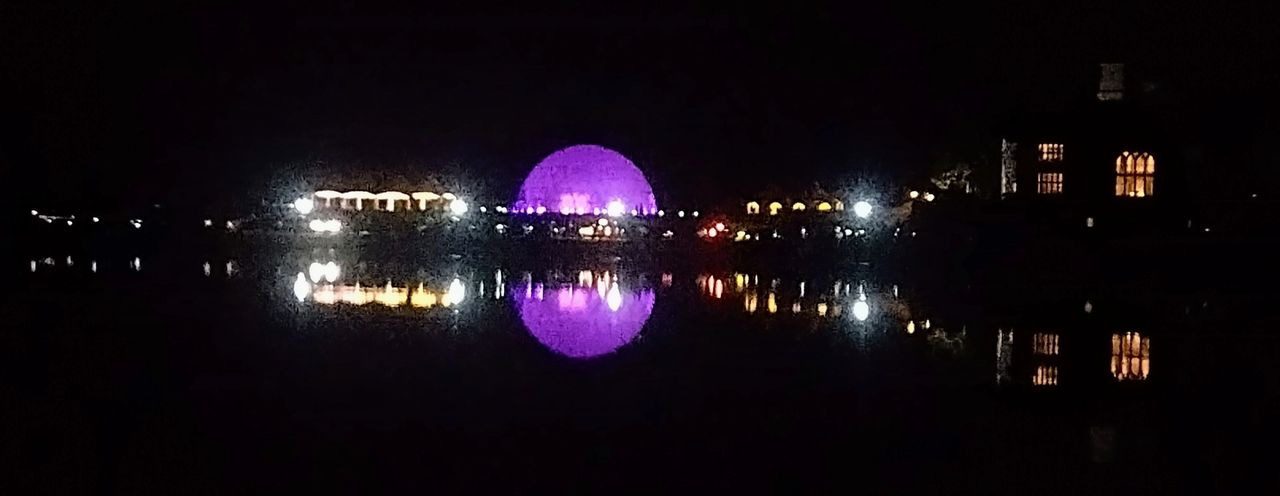 A purple ball is lit up in the night sky.