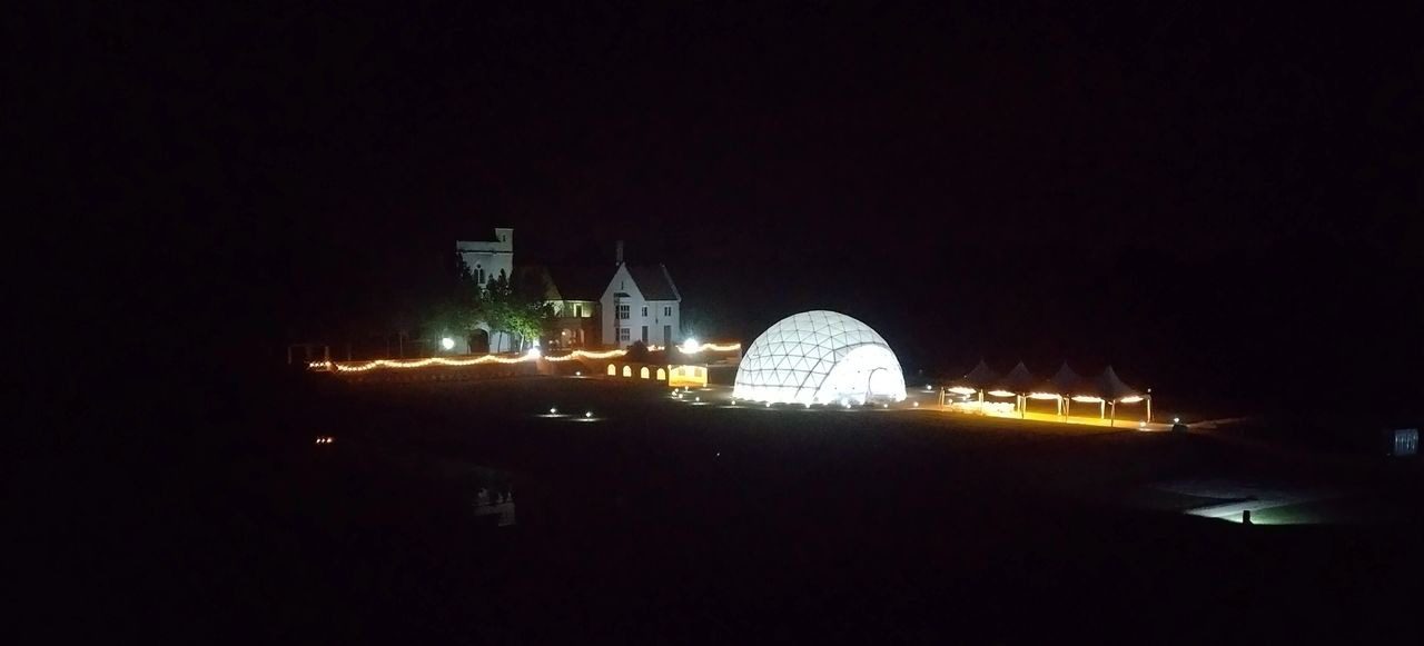 A large white dome lit up at night.