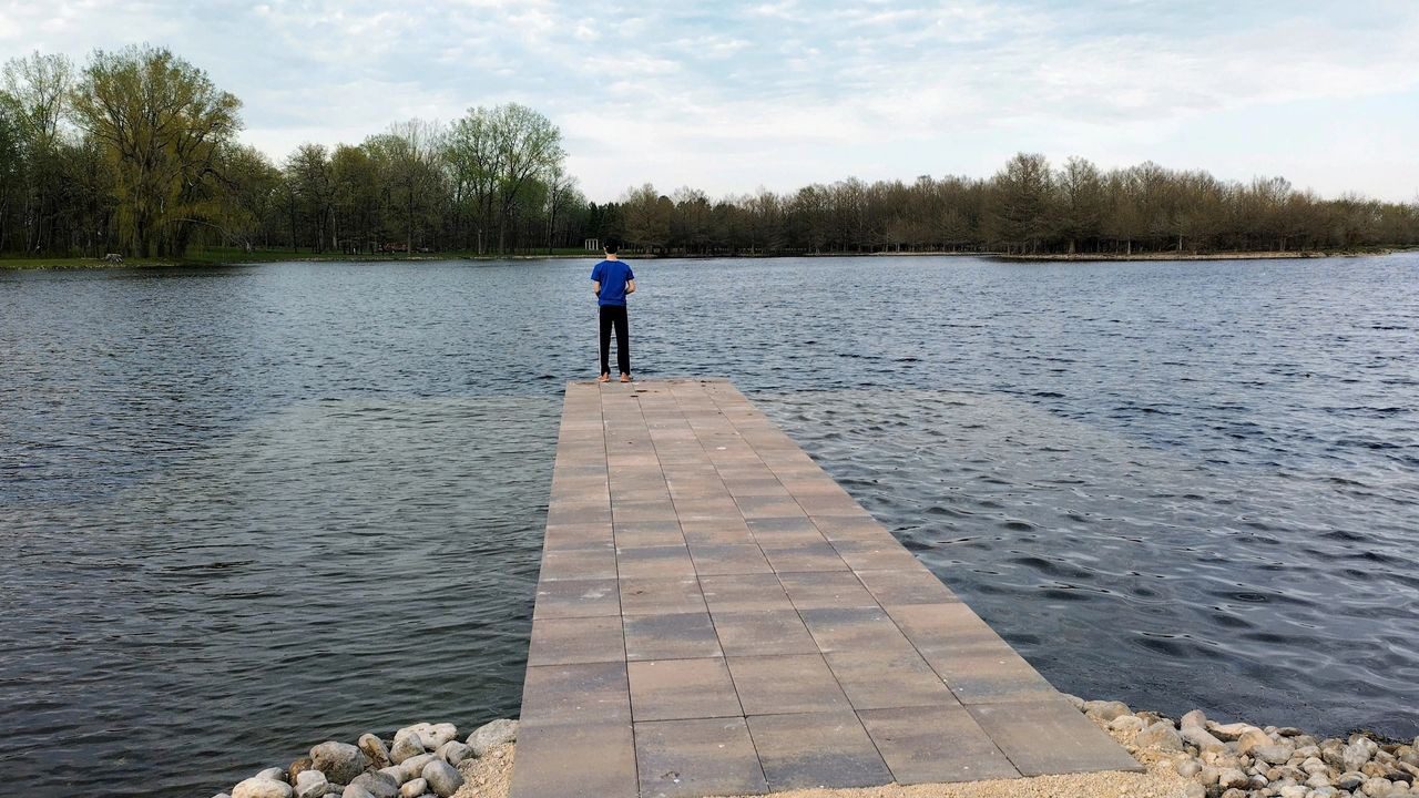 A person standing on the end of a pier.