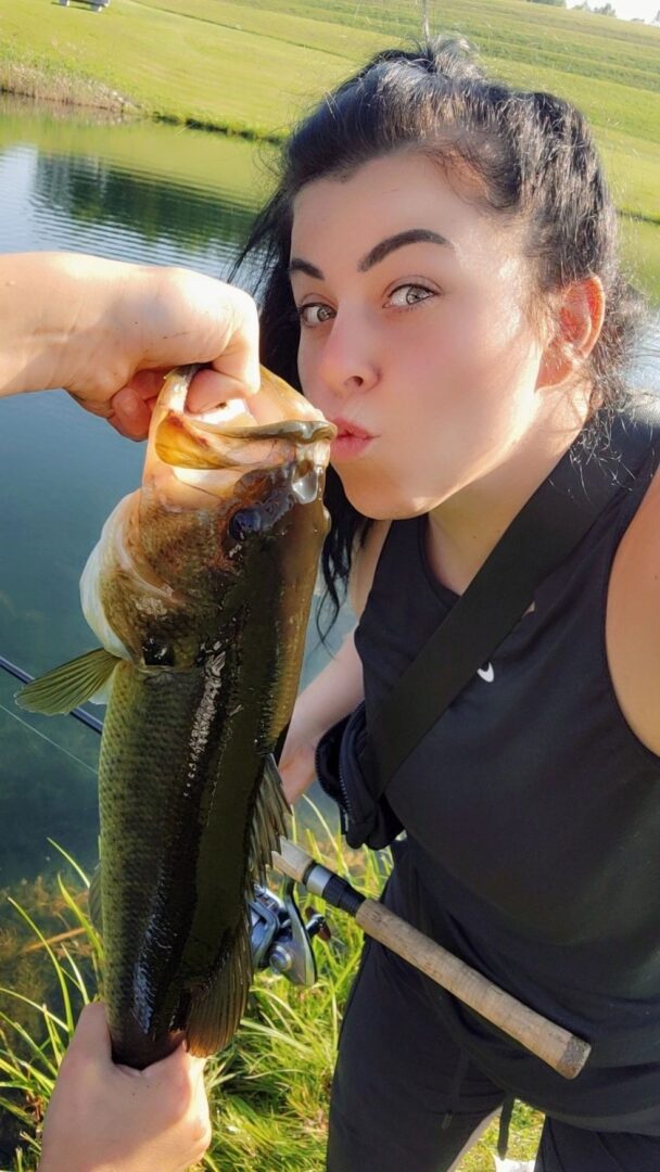 A woman is holding a fish and eating it.