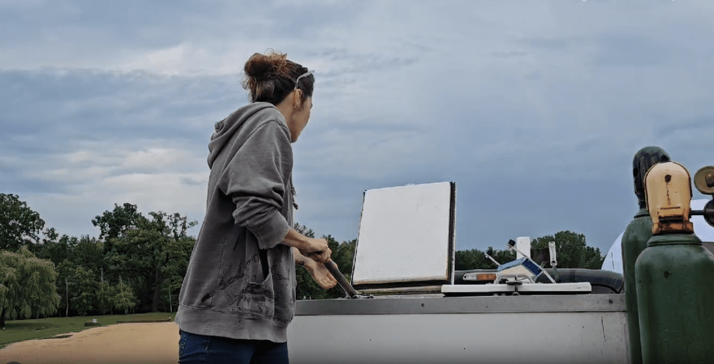 A woman standing next to a laptop on top of a boat.