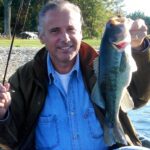 A man proudly holding a large fish he caught.