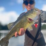 Person proudly holding a large fish caught during fishing.