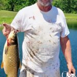 Man proudly holding a large fish he just caught.