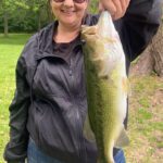 Person proudly holding a large fish outdoors.